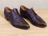 men ' s purple and brown leather shoes on a wooden table