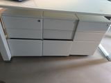 a white desk with drawers and a laptop on top of it