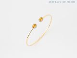 un gros plan d'un bracelet en saphir jaune et diamants sur fond blanc