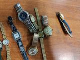 a lot of watches on a table with a pair of pliers