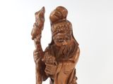wooden statue of a man with a staff and hat holding a staff