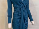 Le mannequin porte une robe bleue à manches longues.