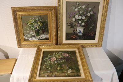 trois tableaux représentant des fleurs posées sur une table recouverte d'une nappe blanche