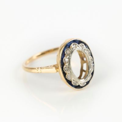 a close up of a gold ring with a blue and white stone