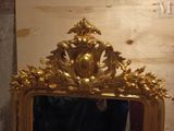 a mirror with a gold frame on the wall