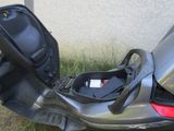 a car seat in the back of a scooter parked on the side of the road