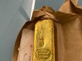 a gold bar in a brown paper bag on a table