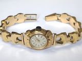 une image représentant une montre en or avec un cadran blanc et un bracelet en or