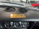 a dashboard of a car in a showroom with other cars
