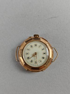 a small gold pocket watch with roman numerals on the face