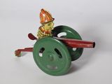un petit jouet représentant un pompier sur une roue verte
