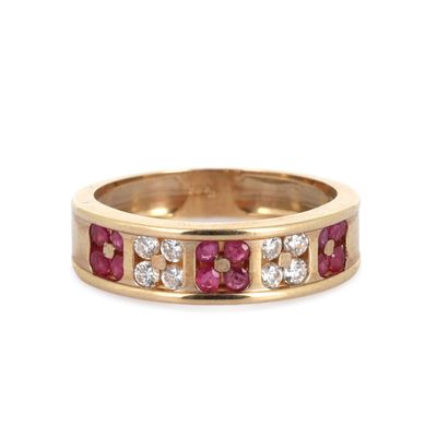 Gros plan sur une bague en or jaune sertie de rubis et de diamants