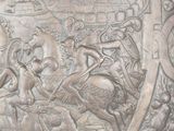 a silver plate with a picture of a man and a woman riding on horses