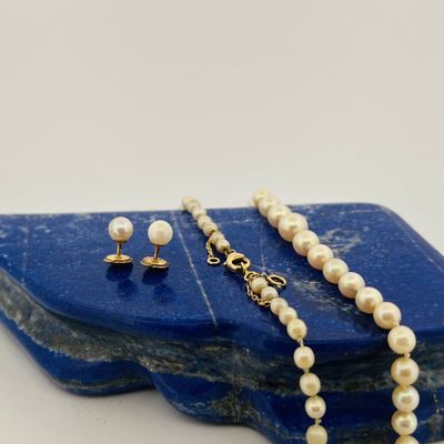 necklace and earring set with pearls on a blue stone