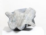 a gray sculpture on a white pedestal on a white surface