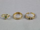 trois bagues en or et une bague sertie d'une pierre verte