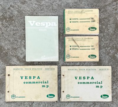 Plusieurs anciennes cartes de visite Vespa sont disposées par terre