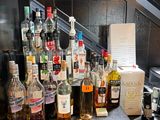 de nombreuses bouteilles d'alcool posées sur un comptoir près d'un escalier