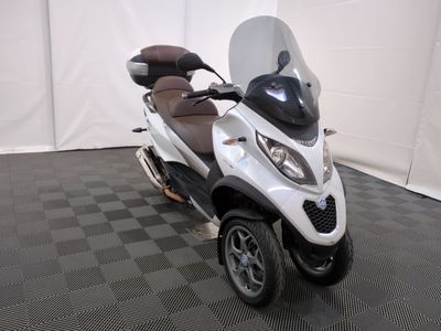 une photo d'un scooter garé sur un sol à damier