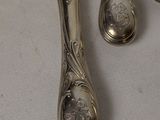 three silver spoons and a knife on a table