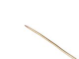 a gold stick that is sitting on top of a white surface