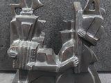 a metal sculpture of a man and woman sitting on a motorcycle
