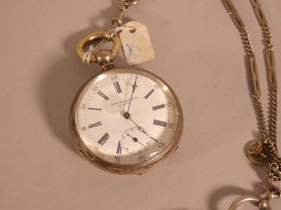 une montre à gousset en argent à laquelle est attachée une chaîne