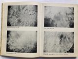 an open book with black and white photos of clouds in the sky