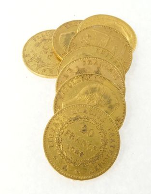plusieurs pièces d'or posées sur une surface blanche, sur fond blanc