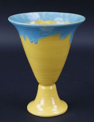 un vase jaune et bleu sur fond noir