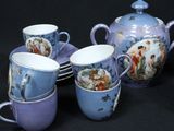 five cups and a teapot sitting on a table