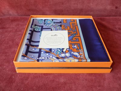 une boîte orange avec un foulard bleu et blanc et un foulard violet et bleu