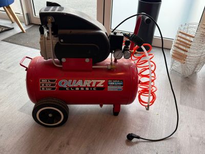 un petit compresseur d'air posé par terre devant une fenêtre