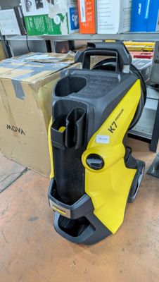 Le compresseur jaune et noir est posé par terre à côté des cartons.
