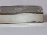 a small silver box sitting on top of a white table
