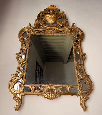 un miroir doré accroché au mur d'une pièce