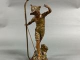 an antique bronze figurine of a man with a staff and a dog