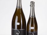 deux bouteilles de champagne posées l'une à côté de l'autre sur une surface blanche