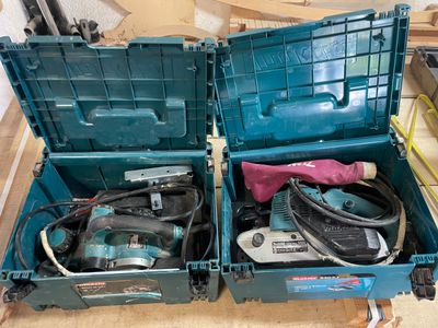deux caisses à outils bleues posées par terre, contenant des outils