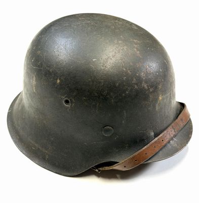 an old black helmet with a leather band on a white surface