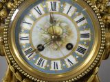 a gold clock with a blue and white design on it