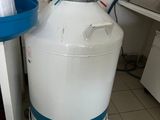 a large white tank sitting next to a blue bucket