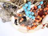 a pile of assorted jewelry on a white surface