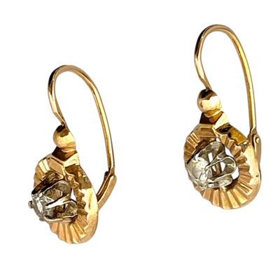 paire de boucles d'oreilles dorées ornées de cristaux transparents sur fond blanc