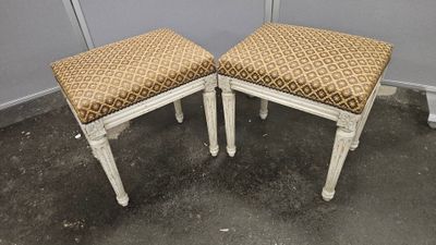 une paire de tabourets peints en blanc, avec des coussins rembourrés