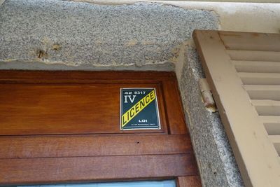une pancarte sur la porte d'un immeuble sur laquelle est inscrit « TV »
