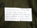 a piece of paper with writing on it sitting on a jacket