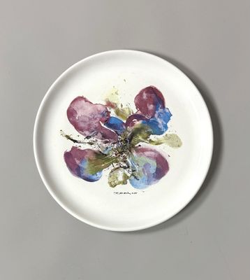 a white plate with a painting of flowers on it