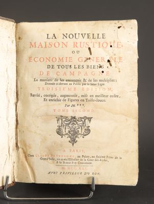 an open book on a metal stand with a black background