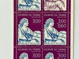 a stamp with a picture of a woman sitting on a chair